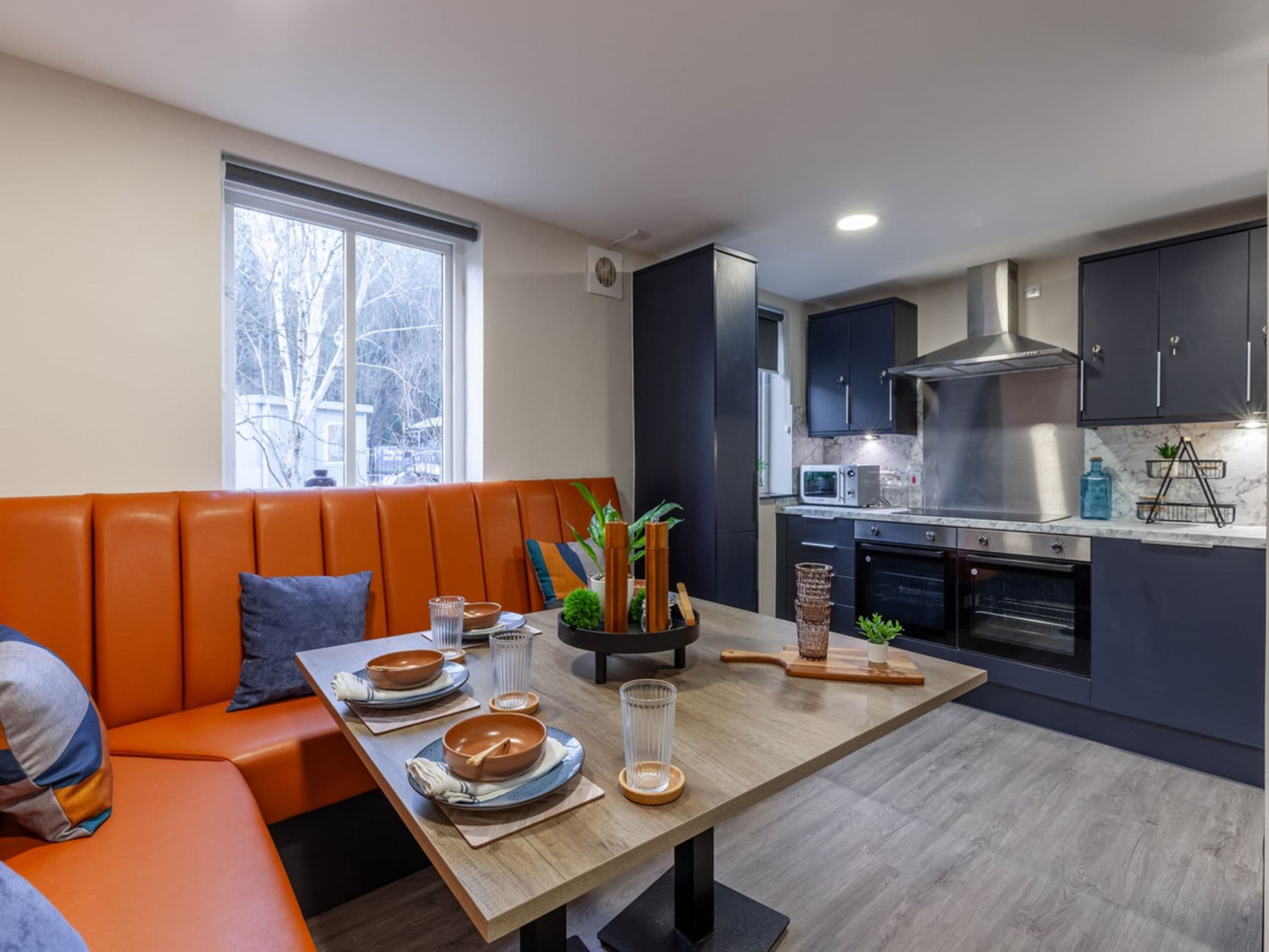 A photograph of The Leather Works kitchen with orange leather seats and a table.