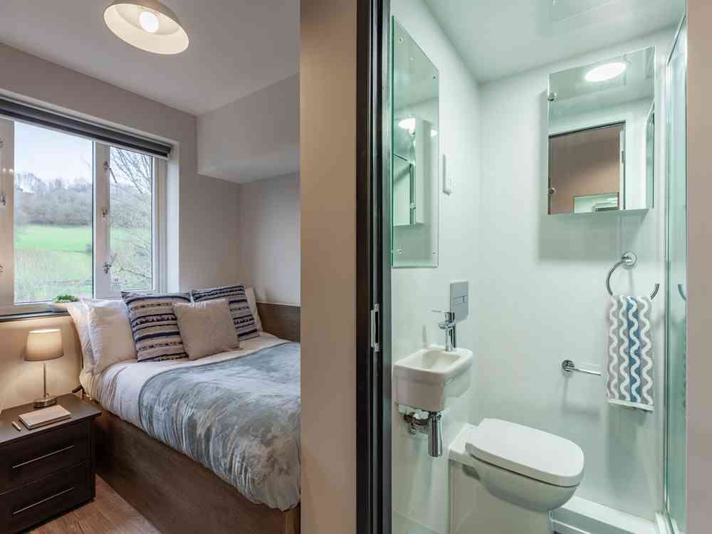 A photograph of a bedroom with the ensuite bathroom in shot.
